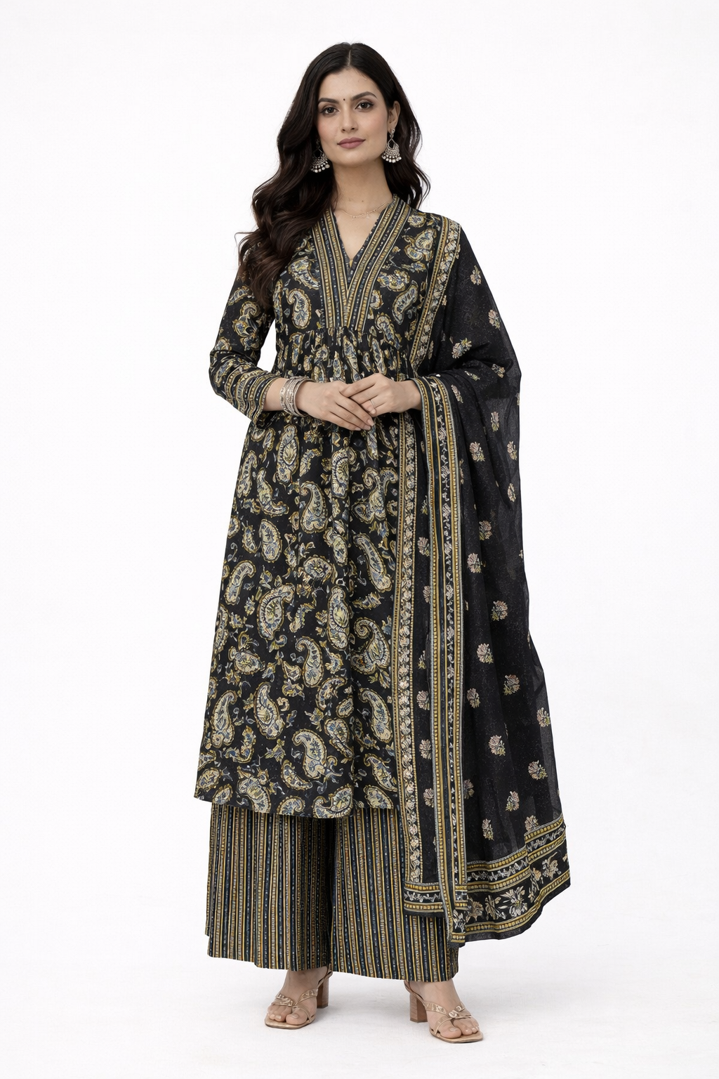 Woman wearing a black and gold traditional paisley print outfit with a dupatta on a white background
