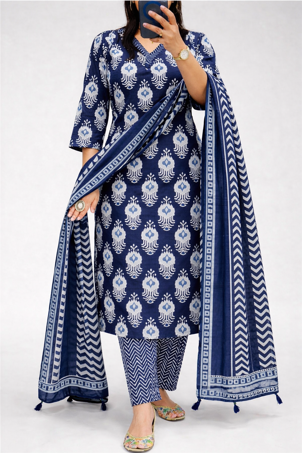 Woman wearing a blue and white patterned outfit with a matching dupatta on a white background